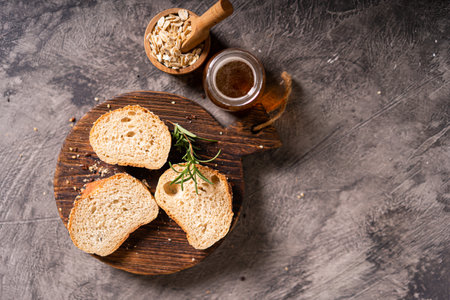 Artisan bread whole wheat baguette white milk and honey on rustic wooden board and abstract table....