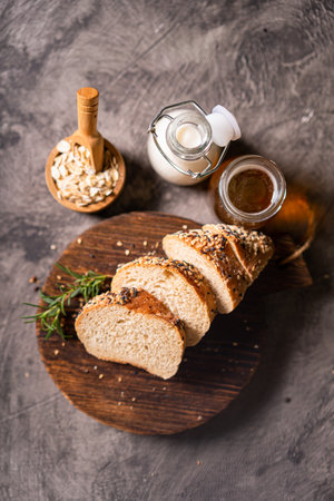 Artisan bread whole wheat baguette white milk and honey on rustic wooden board and abstract table. Sourdough breadの写真素材