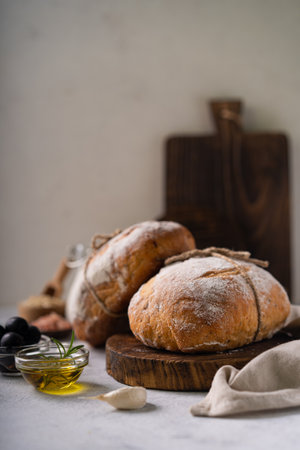 Fresh organic homemade artisan ciabatta bread with herbs, olive oil and olives on white rustic background. sourdough breadの写真素材