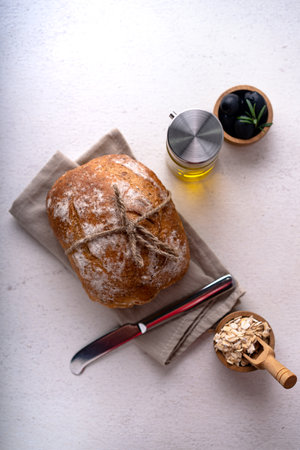Freshly baked sourdough ciabatta bread with olives and rosemary on a white abstract table. Artisan breadの写真素材