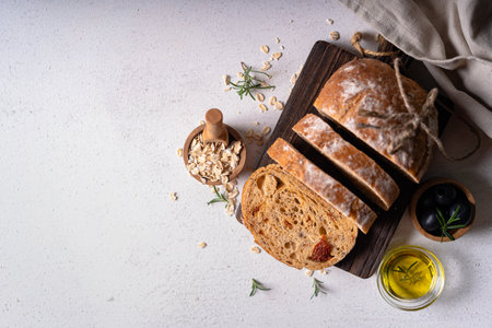 Homemade sourdough ciabatta slice bread with olives and rosemary on a white abstract table. Artisan breadの写真素材
