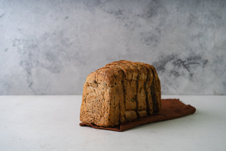 Fresh Sliced Homemade Wholegrain Wheat Bread whit olive oil on white rustic background. Artisan...