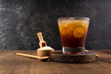 Cuba libre cocktail with lime and ice on wooden background.の写真素材