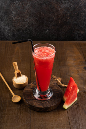Watermelon smoothie in a tall glass on a dark background.の写真素材
