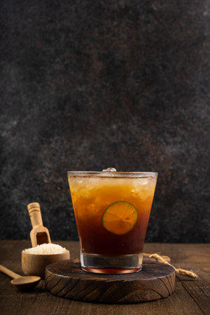 Cuba libre cocktail with lime and ice cubes on wooden backgroundの写真素材