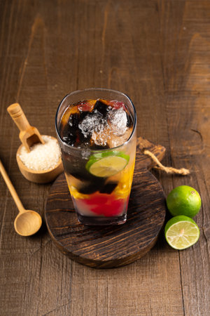 Close up of a glass of sangria with fruits on wooden background