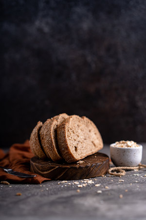 Fresh slices of home baked artisan sourdough bread on white rustic dark background. german rye breadの写真素材