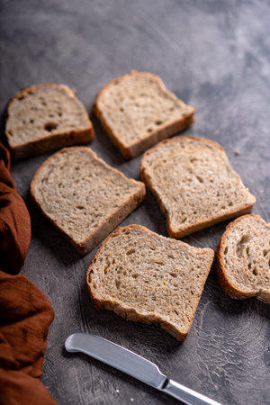 Sliced whole grain loaf bread on dark rustic wooden backgroundの写真素材