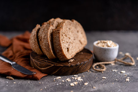 Fresh slices of home baked artisan sourdough bread on white rustic dark background. german rye breadの写真素材