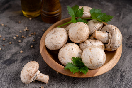 Raw white mushrooms champignons and pepper on grey background for cooking fresh ingredients. free copy spaceの写真素材