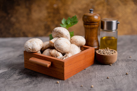 Raw white mushrooms champignons and pepper on grey background for cooking fresh ingredients. free copy spaceの写真素材