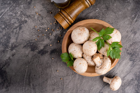 Raw white mushrooms champignons and pepper on grey background for cooking fresh ingredients. free copy spaceの写真素材