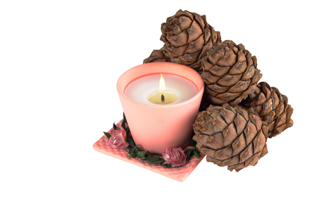 one pink candle and pine cones on a white backgroundの写真素材