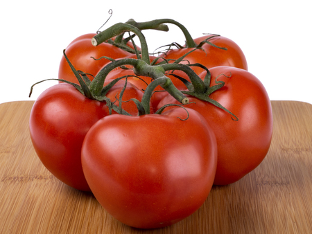 red tomatoes on a twig, lie on a wooden board, image on a white backgroundの写真素材