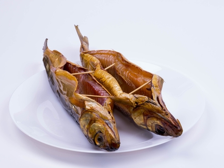 two smoked baikal omul on a white plateの写真素材