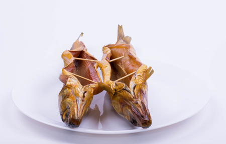 two smoked baikal omul on a white plateの写真素材