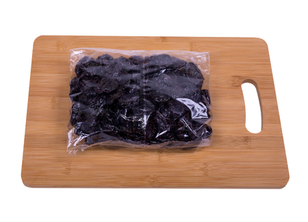 prunes in a package on a wooden board, background whiteの写真素材