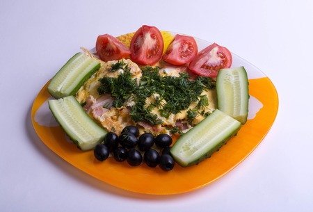 omelet with bacon, tomatoes, cucumbers, olives and dill on a white backgroundの写真素材