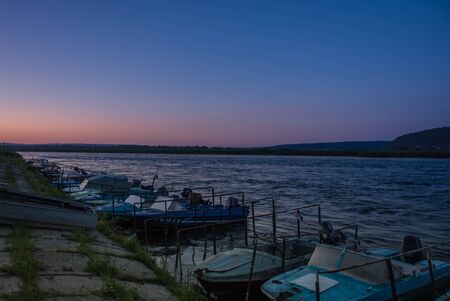 Jetty with many fishing boats on the Angara River in the evening at sunsetの写真素材