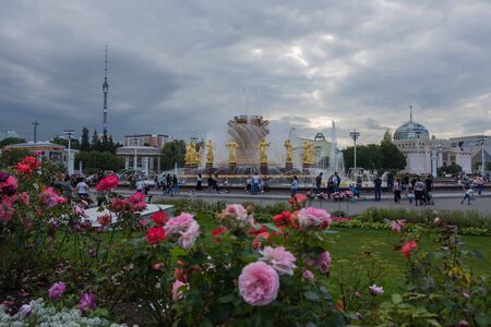 Moscow, VDNKh September 02, 2019 view of a beautiful working fountain and many roses near it in VDNH park on a cloudy fall dayのeditorial素材