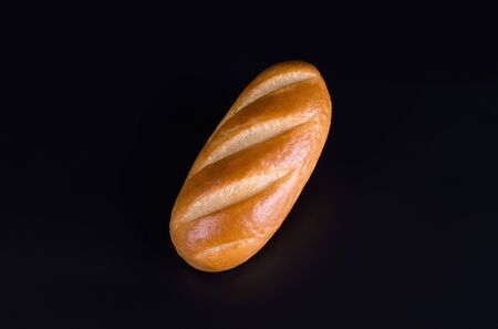 loaf of white bread close-up on a black background, top view