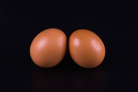two brown eggs close-up on a black backgroundの写真素材