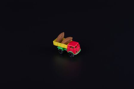 two brown mehndal nuts on a toy truck, photo on a black backgroundの写真素材