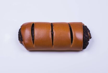 one tasty roll with poppy seeds on a white plate, top viewの写真素材