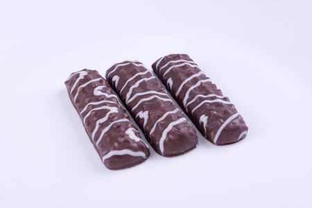 three sweet glazed cookies on a white background, side view