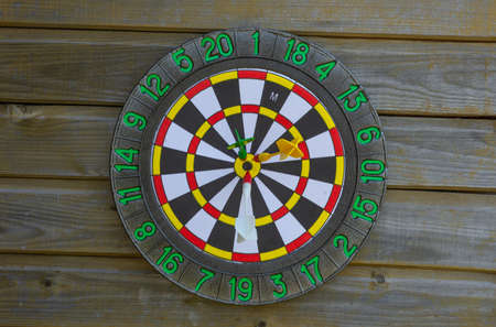 darts game weighs on a wooden wall in the street, close-up, side view