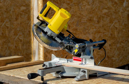 miter saw with yellow body, photo taken on a sunny summer dayのeditorial素材