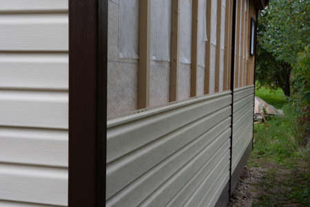 finishing of a country house with ivory siding, photo was taken on a cloudy summer day