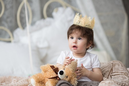 Closeup funny little princess girl in pink crown and dress posing on tent background. Preschooler close up portrait with copy spaceの写真素材