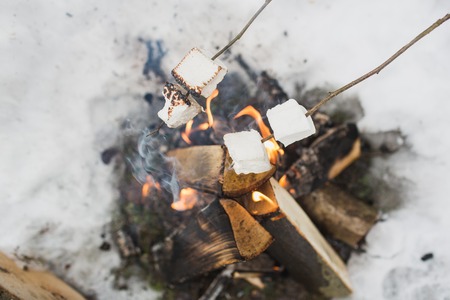 marshmallow on a stick being roasted over a camping fireの写真素材