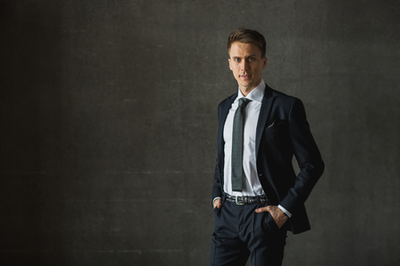 Handsome businessman in formal suit on gray backgroundの写真素材