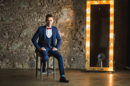 young businessman in blue suit emotional posingの写真素材
