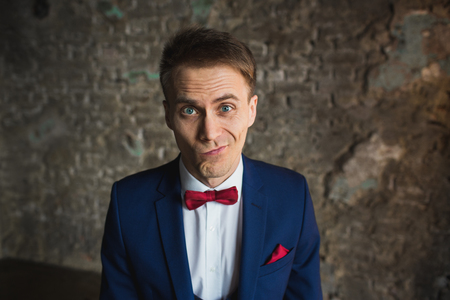 young businessman in blue suit emotional posingの写真素材