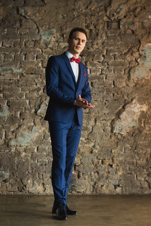 young businessman in blue suit emotional posingの写真素材