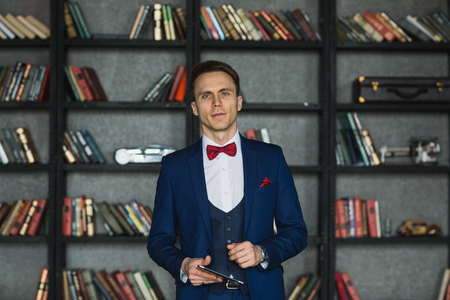 young businessman in blue suit emotional posing with tabletの写真素材