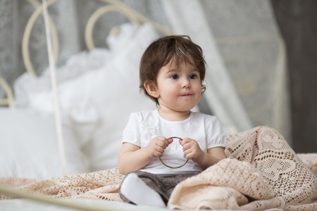 Happy little girl sitting in badの写真素材