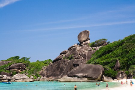 Island with Sailing Boat Rock in Similan National park, Phang Nga, Thailand. Tourists arrive by boat and to walk through the waves to the beachの写真素材