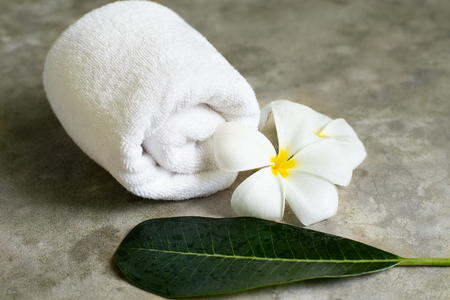 spa towel with plumeria on the grey stone table.の写真素材