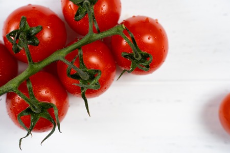 Fresh cherry tomatoes on a white wood background.の写真素材