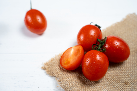 Fresh cherry tomatoes on a white wood background.の写真素材