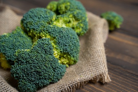 Fresh broccoli and cherry tomatoes on a dark wood background.の写真素材