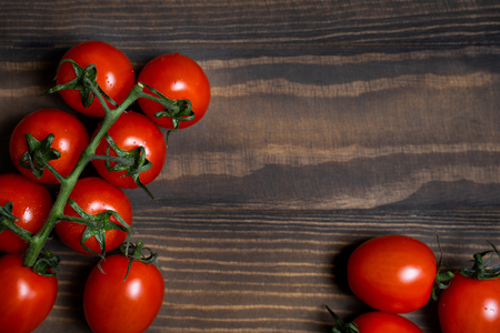 Fresh cherry tomatoes on a dark wood background.の写真素材