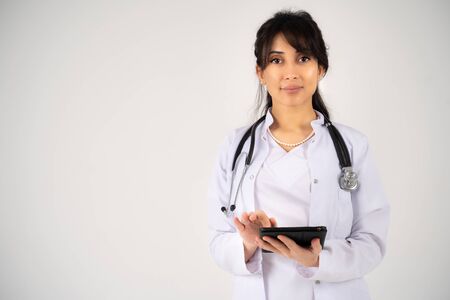 A young girl doctor or student stands with a tablet in her handsの写真素材