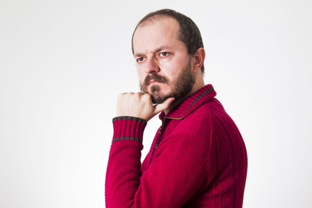 Man in red sweater, with beard and mustaches in skeptic poseの写真素材