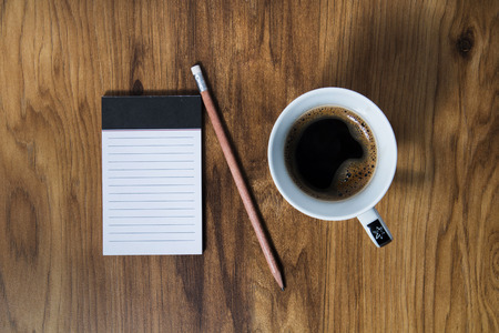 Cup of coffee and notepad on the table