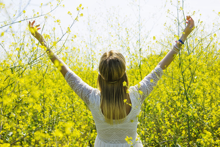 Girl in field full of yellow flowers
